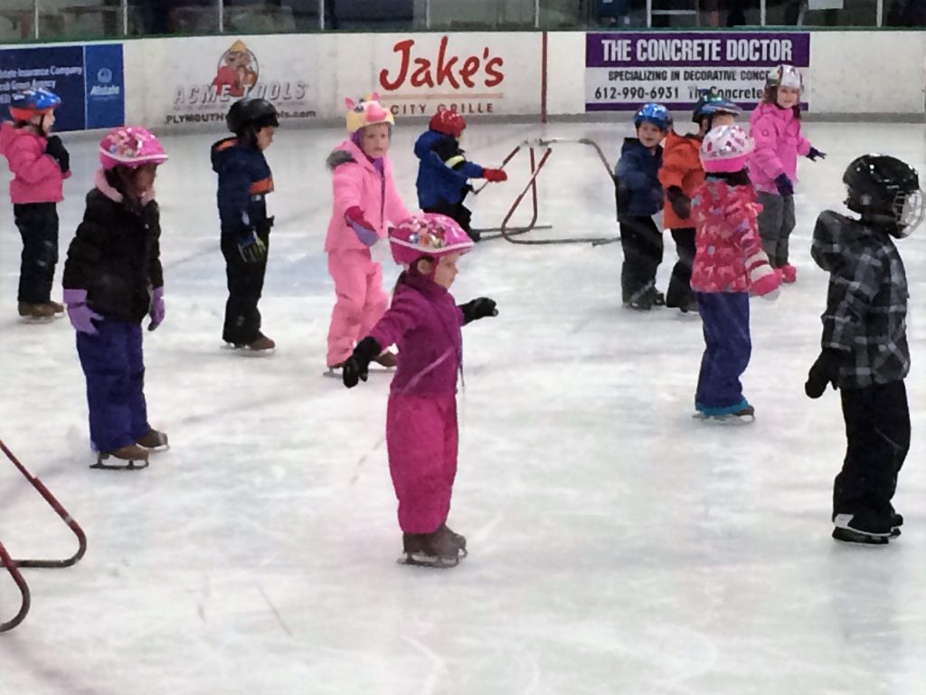 Young beginner ice skaters make progress during group lessons